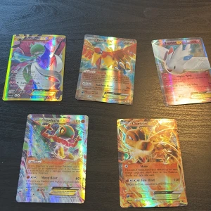 Pokémon EX Holo Collection - Samling med fem glittrande Pokémon EX-kort: Gardevoir, Ho-Oh, Togekiss, Hawlucha och  en sällsynt Charizard. Perfekt för dig som älskar coola och sällsynta kort med färgstarka motiv och kraftfulla attacker. Gör din samling extra unik och byt eller spela med vänner!