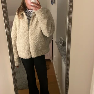 Beige teddyjacka från Zara, S - Säljer en fluffig och oversized teddyjacka från Zara i beige. Jackan har långärmade ärmar, dragkedja framtill och är gjord i mjukt syntetmaterial med krullig yta. Perfekt för dig som vill ha en mysig och trendig look under höst och vinter.