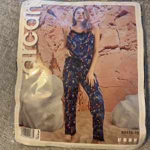 Blå pjamassätt  med färgglada fjädrar - Pjamassätt. Aldrig använd kvar i förpackning. Storlek s. 