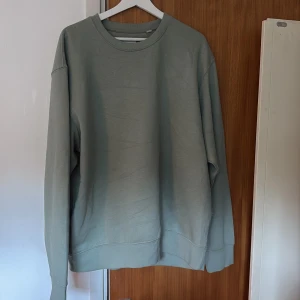 Grön sweatshirt från Jack & Jones - Snygg ljusgrön sweatshirt från Jack & Jones med rund hals och ribbade muddar. Tröjan har en clean och enkel design utan mönster, perfekt för dig som gillar stilrena plagg. Tillverkad i mjuk bomull och har en normal passform med långa ärmar.