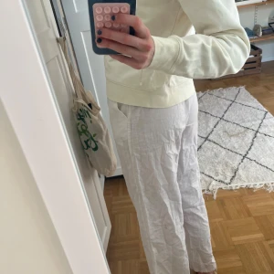 Vita linnebyxor med snörning - Säljer ett par chill vita linnebyxor med elastisk midja och snörning framtill. Byxorna har raka ben och är gjorda i ett lätt och luftigt linnematerial, perfekt för varma dagar. De har fickor på sidorna och en loose passform som ger en avslappnad vibe. Skriv vid minsta fråga!💕💕