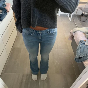 Bootcut jeans från ONLY, ljusblå - Säljer ett par ljusblå bootcut jeans från ONLY med klassisk femficksdesign och normal midja. Jeansen har en snygg tvätt med lätt slitning framtill och är tillverkade i mjukt denimtyg med stretch. Passar dig som gillar en retro vibe och vill ha bekväma jeans med lite utsvängda ben.