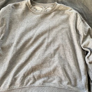 Grå sweatshirt från H&M - Grå oversisez sweatshirt från h&m. den har ett liten hål som syns på sista bilden.