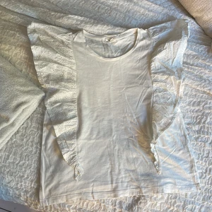 Vit blus med broderade volangärmar KappAhl - Supersöt vit blus från KappAhl med breda volangärmar. Använd med inga skador🤍
