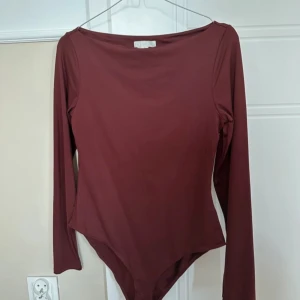 Vinröd långärmad body från H&M - Säljer en vinröd body från H&M i storlek S. Den har lång ärm och är figurnära med rundad hals. Materialet är mjukt och stretchigt, troligen bomull med inslag av syntet. 💞