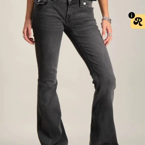 True Religion Jeans - Säljer ett par grå bootcut jeans från True Religion med snygga kontrastsömmar och ikoniska fickdetaljer bak. Jeansen har låg midja och är tillverkade i mjukt denimtyg. Perfekta för dig som gillar en avslappnad men ändå trendig look. Dom är knappt använda men enda tecken av användning är längst ned på benet (se på bild) Nypris 1300
