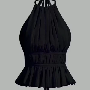 Svart volangig halterneck topp - Supersnygg svart halterneck topp med volangkant nedtill och rynkade detaljer. Toppen har en croppad passform och knyts i nacken och midjan. Perfekt för dig som vill sticka ut med en trendig och elegant look.