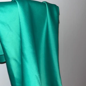 Grön/turkos lite kort satinkjol från Ginatricot - Kjolen har en kort längd och en slät, glansig yta. Mjuk