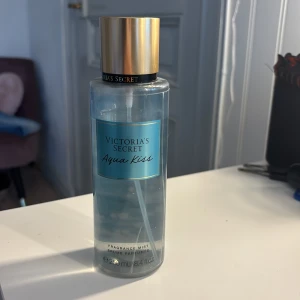 Victoria's Secret Aqua Kiss mist  - Fräsch body mist från Victoria's Secret i doften Aqua Kiss. Flaskan är genomskinlig med blå etikett och guldfärgat lock. Doften beskrivs som cool waters och bright daisy. Perfekt för dig som gillar lätta och fräscha parfymer. Mycket kvar i flaskan💗Kom gärna med pris förslag! 