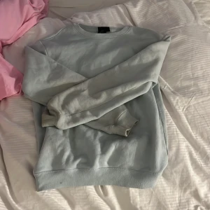 Ljusgrå sweatshirt från H&M - Säljer en ljusgrå sweatshirt från H&M i relaxed fit. Tröjan har rund halsringning, långa ärmar och ribbade muddar vid ärmslut och nederkant. Perfekt för en avslappnad stil.