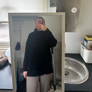 Svart stickad polotröja - Säljer en svart stickad polotröja med lång ärm. Tröjan har en oversized passform och är perfekt för kyligare dagar. Enkel och stilren design som passar till det mesta.