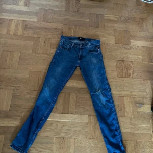 Blå Replay jeansbyxor herr - Säljer ett par klassiska blå jeans från Replay, modell M914Y. Byxorna har fem fickor, normal passform och raka ben. Midjemått W29 och längd L32. Perfekta till vardags och lätta att matcha med olika stilar.