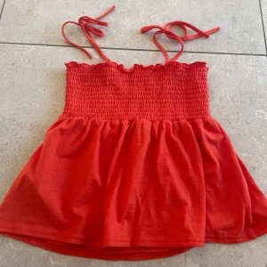 Sommartopp - Säljer en röd/orange linnetopp från Vero Moda med knytband då den är för liten för mig. Toppen har används ett fåtal gånger men är i nyskick. 