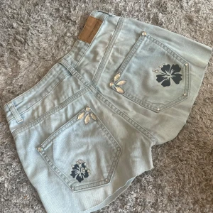 jeansshorts med blommor och rhinestones  - jeans klippta till shorts i storlek s från gina tricot. stenarna är limmade och trycket är handgjort så det håller INTE i tvättmaskinen, endast handtvätt!  använd ”köp nu” 1/5-2025