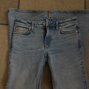 Ljusblå bootcut jeans - Säljer ett par ljusblå jeans med klassisk femficksdesign och bootcut-ben. Jeansen har normal passform och är tillverkade i denim med lätt tvättad look. Perfekta för dig som gillar retrostil och vill ha ett par snygga jeans med utsvängda ben. Säljer för att jag inte använder dem 