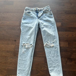 Ljusblå slitna jeans från g perfect jeans - Ljusblå jeans med raka ben och slitningar över båda knäna. Klassisk femficksmodell med normal passform och hög midja. Perfekta för en avslappnad och trendig look.