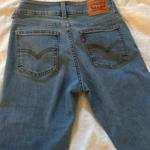 Levi's blåa jeans, storlek 25 - Ljusblå jeans med en låg midja och utsvängda ben