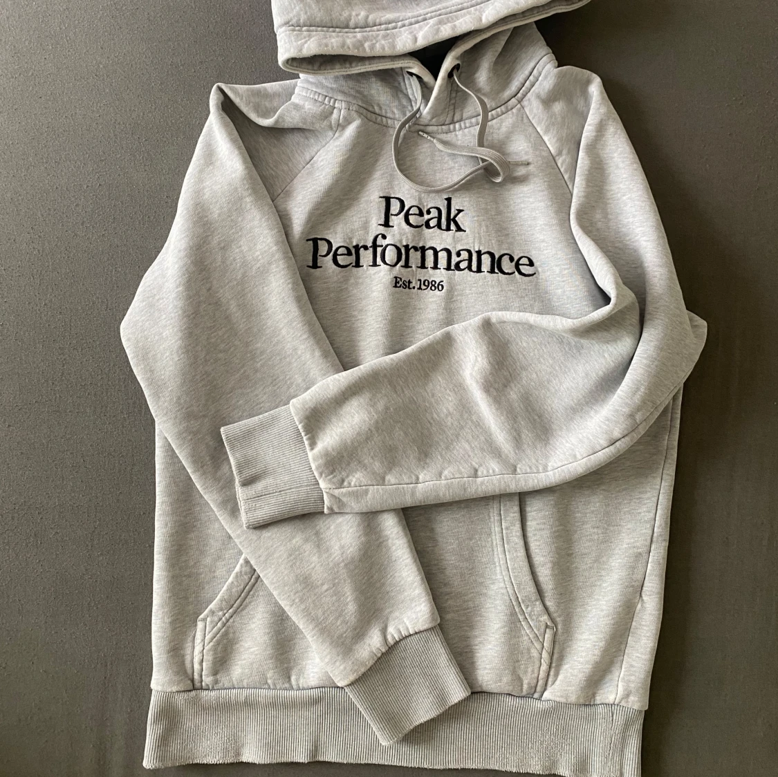 Ljusgrå hoodie från Peak Performance