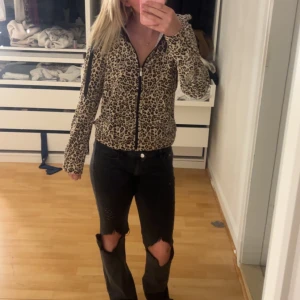 Leopardmönstrad zip-jacka - Säljer en leopardmönstrad jacka med dragkedja framtill. Jackan har lång ärm och en figurnära passform. Perfekt för dig som vill sticka ut med ett djurmönster i garderoben.