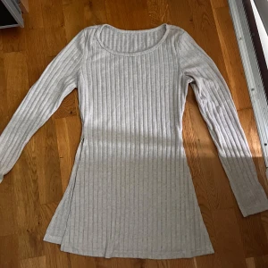 Ljusbeige ribbad långärmad sett - Säljer ett ljusbeige ribbad sett i mjukt material. Tröjan har rund halsringning och en figurnära passform som följer kroppen. Perfekt för dig som gillar enkel och stilren design.