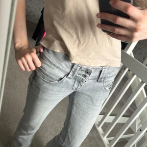 Grå jeans från Pepe Jeans - Snygga grå jeans från Pepe Jeans med låg midja och rak passform. Perfekta för en avslappnad stil. De har en klassisk design med knappar och dragkedja framtill. Säljer då de är för korta för mig på 177🩷