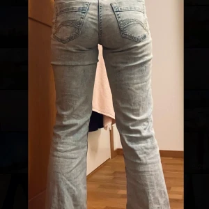 Ljusblå bootcut jeans - Snygga ljusblå bootcut jeans med klassisk femficksdesign och knappgylf. Perfekta för en avslappnad stil med en touch av retro. De har en bekväm passform och är tillverkade i ett mjukt denimtyg.