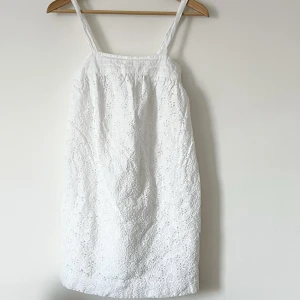 Vit spetsklänning med axelband  - Söt vit klänning med axelband och vackert spetsmönster. Storlek M, passar XS/S