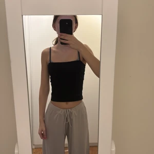 Svart linnetopp från Gina Tricot - Säljer en stilren svart linnetopp från Gina Tricot. Toppen har smala axelband och en enkel design som passar perfekt till olika outfits. Storlek S och använd fåtal gånger. 