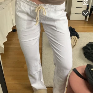 Vita linnebyxor med snörning - Snygga vita linnebyxor från ROXY med bekväm snörning i midjan. Jättepopulära och perfekta till vår/sommar! Passar s/m