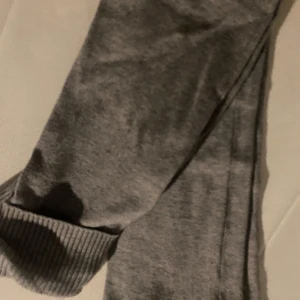 Grå utsvängda stickade byxor från Gina Tricot - Säljer en  grå utsvängd byxa från Gina Tricot. Byxan är  ribbade muddar vid midjan och nederkant. Perfekt för en avslappnad look. Aldrig använd så i nytt skick