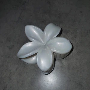 Hårklämma - Snygg vit hårklämma formad som en blomma. Perfekt för att hålla håret på plats med stil. Klämman har en glansig yta och en stark fjädermekanism för bra grepp.