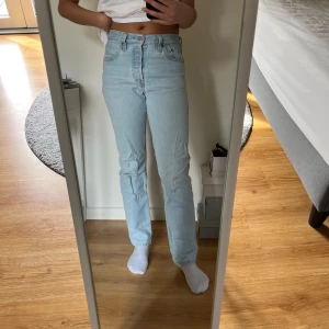 Ljusblå Levi's 501 jeans  - Snygga ljusblå jeans från Levi's med klassisk femficksdesign och medelhög midja. De har en rak passform och är tillverkade i slitstarkt denim. Är lite för korta på mig men passar säkert någon som är kortare än 170 cm. Stängs med knappar. 