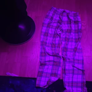 Rutig pyjamasbyxa från Kappahl - Säljer en bekväm rutig pyjamasbyxa från Kappahl i mjukt material. Byxorna har ett klassiskt rutmönster i flera färger och en elastisk midja för extra komfort. Perfekt för mysiga hemmakvällar.