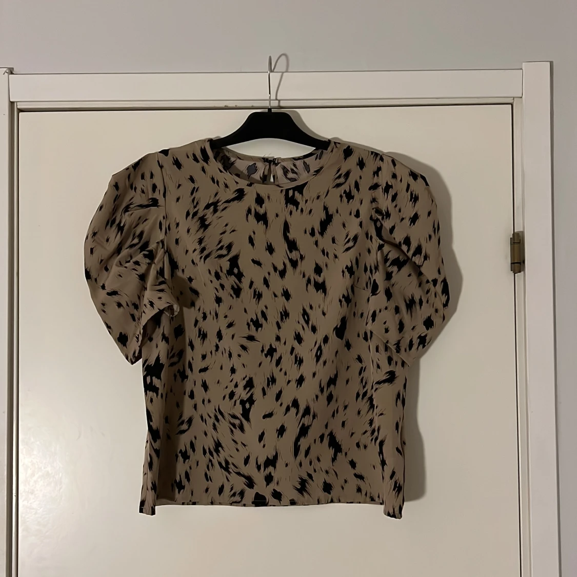 Beige blus med svart mönster