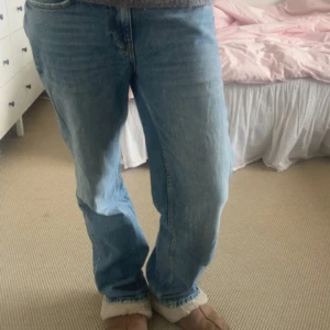 Blå jeansbyxor - Säljer ett par klassiska blå jeansbyxor med straight/ lös / vid  passform. De har en traditionell femficksdesign och är perfekta för en avslappnad stil. Byxorna har en knapp och dragkedja framtill. Passar mellan 170-175cm