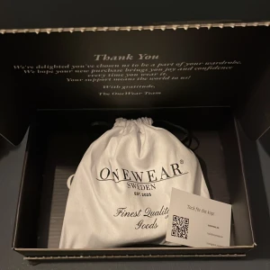 Svart mocka bälte från Onewear - Snyggt svart mocka bälte från Onewear med en stilren silverfärgad spänne. Perfekt för att komplettera din outfit. Kommer i en elegant förvaringspåse. Aldrig använt. Säljer pågrund av för stort.