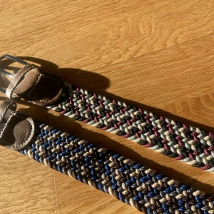 Flätade bälten i olika färger - Två flätade bälten med bruna läderdetaljer. Det ena bältet har en kombination av beige, blå och bruna färger, medan det andra har beige, vinröd och grå nyanser. Perfekta för att ge en färgglad touch till din outfit. Perfekt o styla me ett par feta jeans o en schysst tröja, skriv om ni har nån fundering, går även o köpa bara ett|| pris 150kr för båda || ett för 85kr