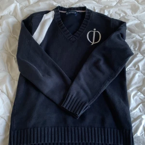 Svart stickad tröja från Oscar Jacobson - Säljer en stilren svart stickad tröja från Oscar Jacobson med v-ringning och ett vitt märke på bröstet. Tröjan har en unik vit detalj på ena axeln och ribbade muddar vid ärmslut och nederkant. Storlek M men sitter som en S. Tveka aldrig på att skriva🤝Skriv prisförslag 