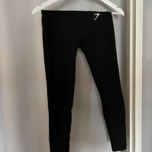 Träningstights Gymshark - Säljer ett par svarta leggings från Gymshark i storlek XS. Hela och fina men i använt skick. 