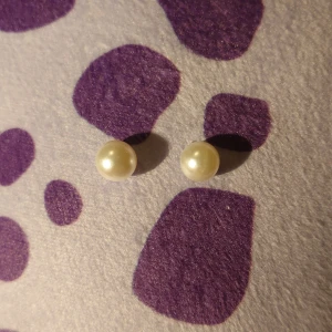 Pärlörhängen studs - Säljer ett par klassiska pärlörhängen som passar perfekt för en elegant look. De är enkla men stilrena och kan bäras vid många tillfällen. Inte använda.