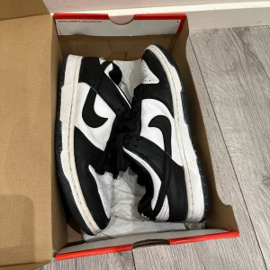 Svartvita panda Nike Dunk skor storlek 40.5 - Säljer mina Nike dunk pandas då jag har vuxit ifrån de, nästan aldrig använt de, de är i väldigt bra skick, kan även fraktas ifall det behövs! Storlek 40.5. Kontakta ifall du har några frågor! 