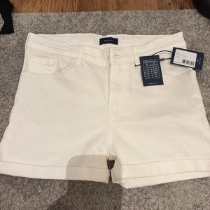 Vita shorts från GANT - Snygga vita shorts från GANT med klassisk design. De har en normal passform och är tillverkade i ett bekvämt material. Storlek 158-164 men de passar även för mig som bär XS/S, jag gillar inte att de är lågmidjade och därför aldrig använda. 🤍