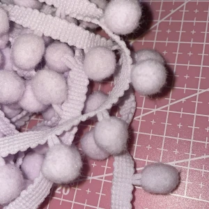 Pom pom .Pompomband Lila - Har pompom band som du kan piffa upp dina prylar med så som kläder el sömnad som du tillverkar själv. Självklart är den inte använd eller sytt med. De är 100 cm långt band. För den som pyssla lite 