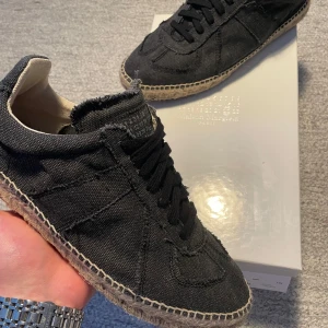 Maison Margiela Espadrilles - Snygga svarta sneakers från Maison Margiela med en unik design. Använda en gång, säljer pågrund av att dom var för små, passar 42-43. Självklart äkta med allt og och kvitto 🧾 ✅