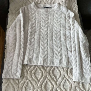 Vit stickad tröja från 157 - Säljer en mysig vit stickad tröja från 157. Tröjan har ett klassiskt flätmönster och långa ärmar. Perfekt för kyliga dagar. Passar bra till både jeans och kjol. Materialet är väldigt lent mot huden. Hör av dig vid intresse! 🤍