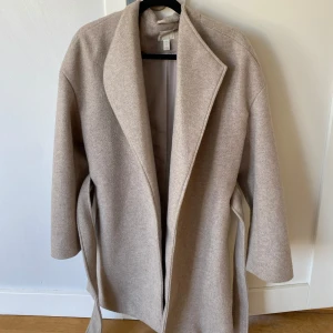 Kappa  med bälte - Beige kappa med bälte. Köpt på hm för ett tag sedan. Perfekt för höst och vår! Storlek XS 