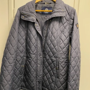 Blå quiltad jacka från Henri Lloyd - Säljer en stilren blå quiltad jacka från Henri Lloyd i storlek XL. Jackan har en dragkedja framtill och långa ärmar. Perfekt för kyligare dagar med sin klassiska design och bekväma passform.
