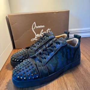 Camo loubs - Snygga sneakers i camouflage från Christian Louboutin med nitar på tån. Skorna har en cool design med snörning och en klassisk röd sula. Väldigt unika och nästan ingen i Sverige som har. Du kommer garanterat vara ensam om att ha dessa