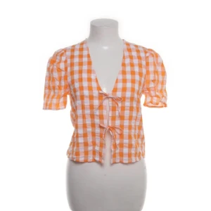 Orangevit rutig blus från Monki - Säljer en orange och vit rutig blus från Monki i storlek XXS. Blusen är för liten för mig. Inga defekter