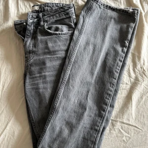 Grå jeansbyxor från Gina Tricot - Snygga grå jeansbyxor från Gina Tricot med klassisk femficksdesign och dragkedja. Byxorna har raka ben och normal passform, perfekta till många olika stilar.